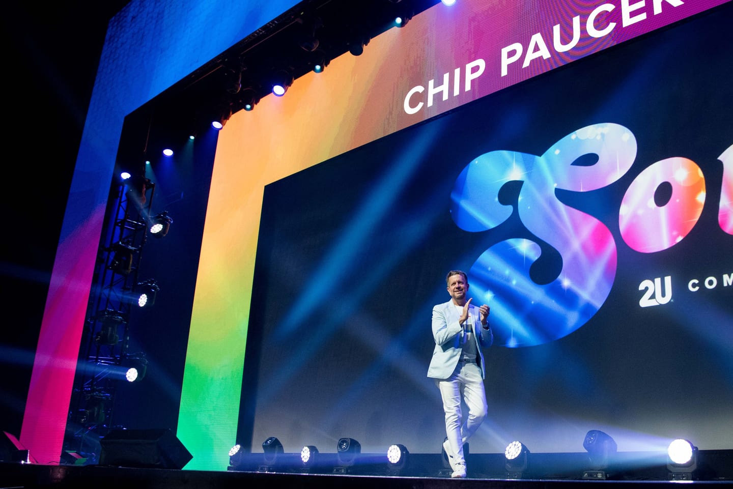 CEO Chip Paucek on a rainbow-lit main stage at the 2U SOUL company meeting keynote