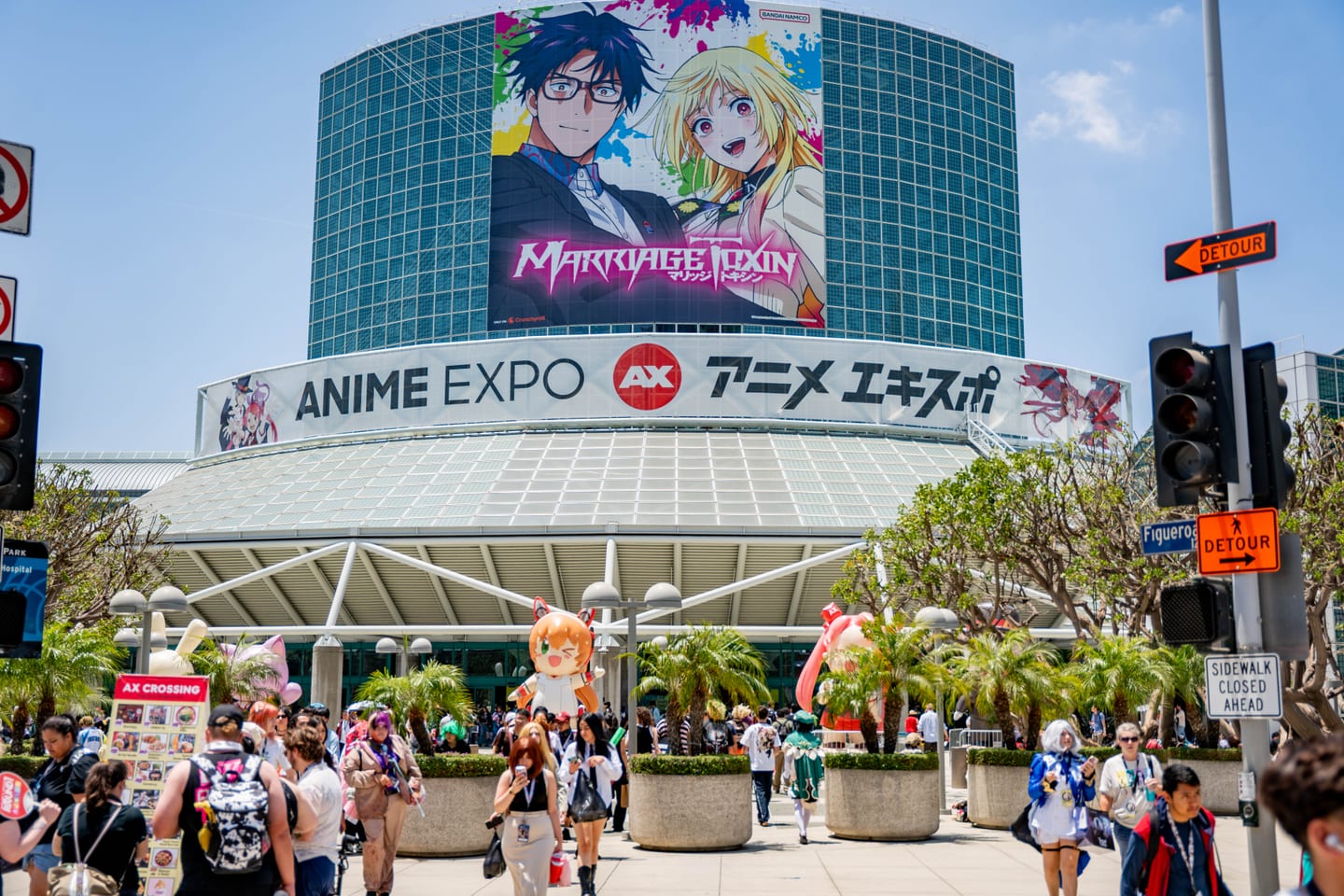 The Los Angeles Convention Center globe wrapped for Anime Expo 2026 with a giant Marriage Toxin banner and the ANIME EXPO AX アニメ エキスポ marquee, crowds streaming in below