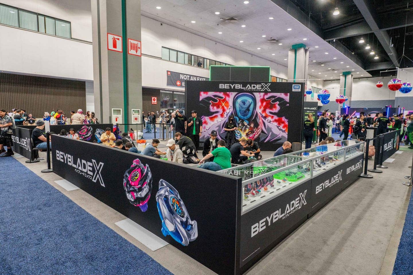 The Beyblade X branded activation booth and tournament arena with attendees at Anime Expo
