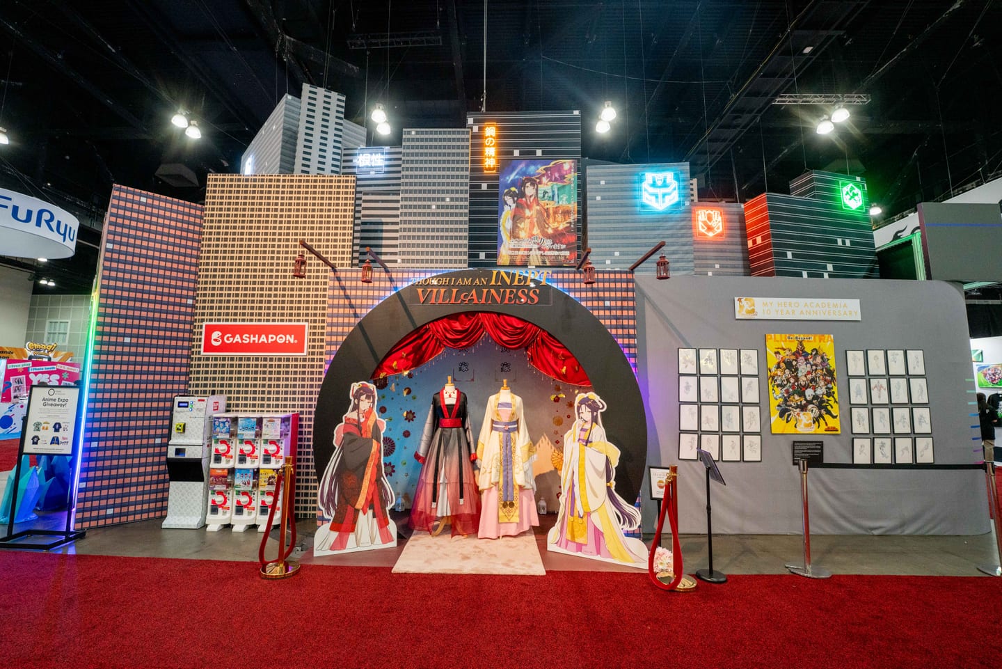 The Bandai Gashapon booth at Anime Expo 2026, an archway of capsule-toy machines with anime character standees on a red carpet