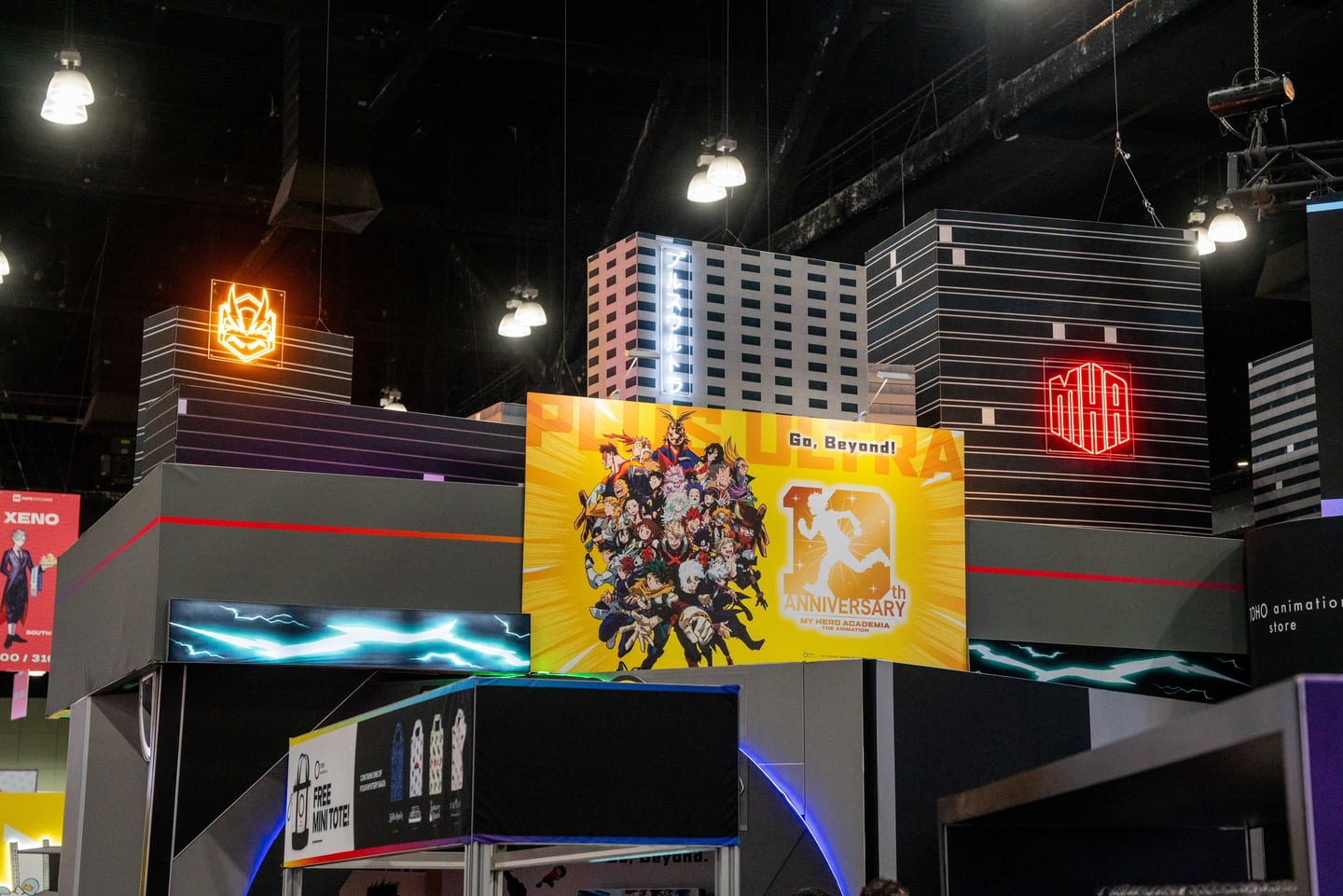 A tall My Hero Academia 10th Anniversary exhibitor booth with a cityscape build and character mural at Anime Expo