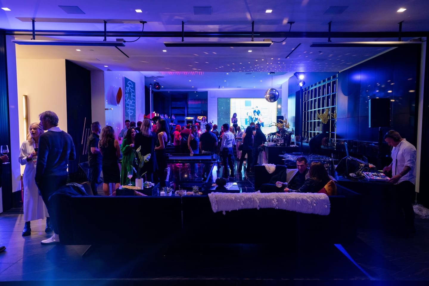 Crowd on the floor under blue lighting at a private birthday party in Los Angeles