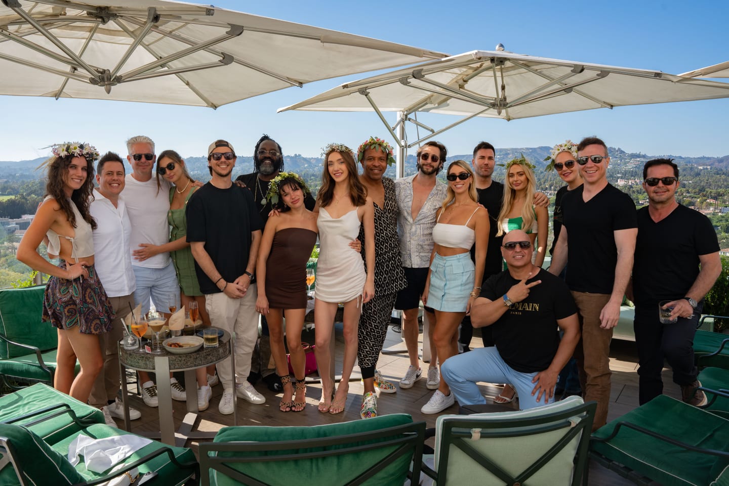 A large group of guests posing together at a rooftop birthday party in Beverly Hills