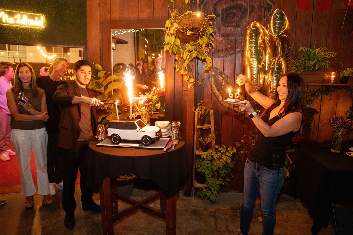 A car-shaped cake lit with sparklers carried out at a themed birthday party in Los Angeles