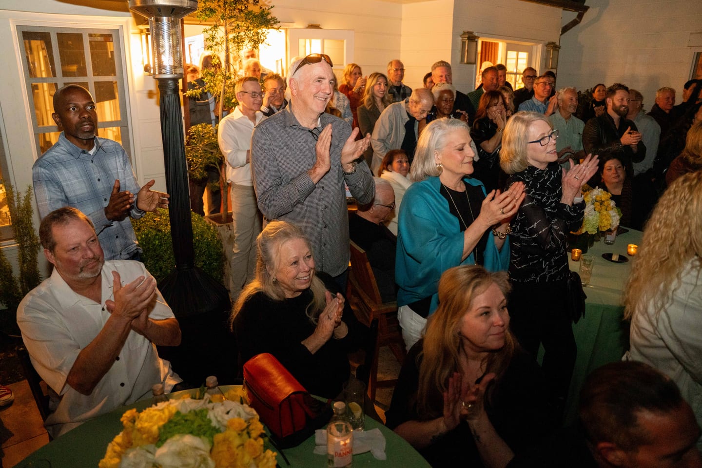 Guests applauding a toast at an outdoor private birthday celebration in Los Angeles