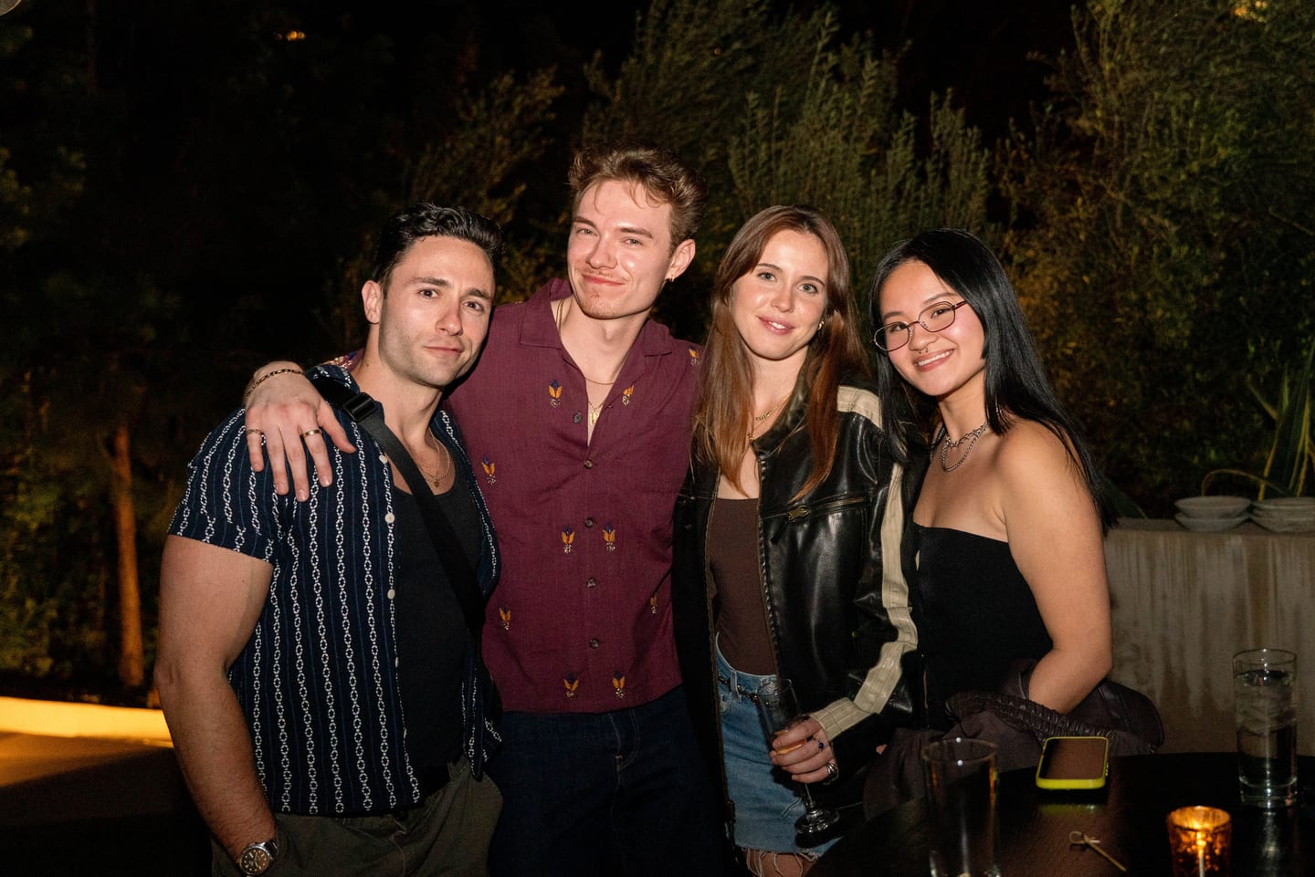 Four young guests posing together at an evening birthday party in Los Angeles