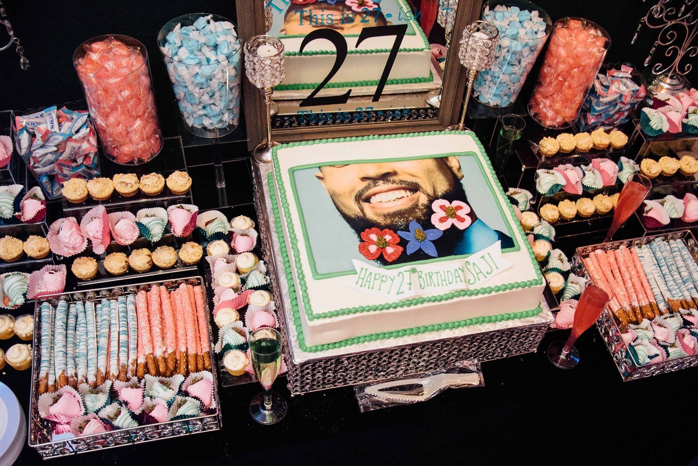 Birthday cake with a printed photo on a dessert and candy table at a 27th birthday party
