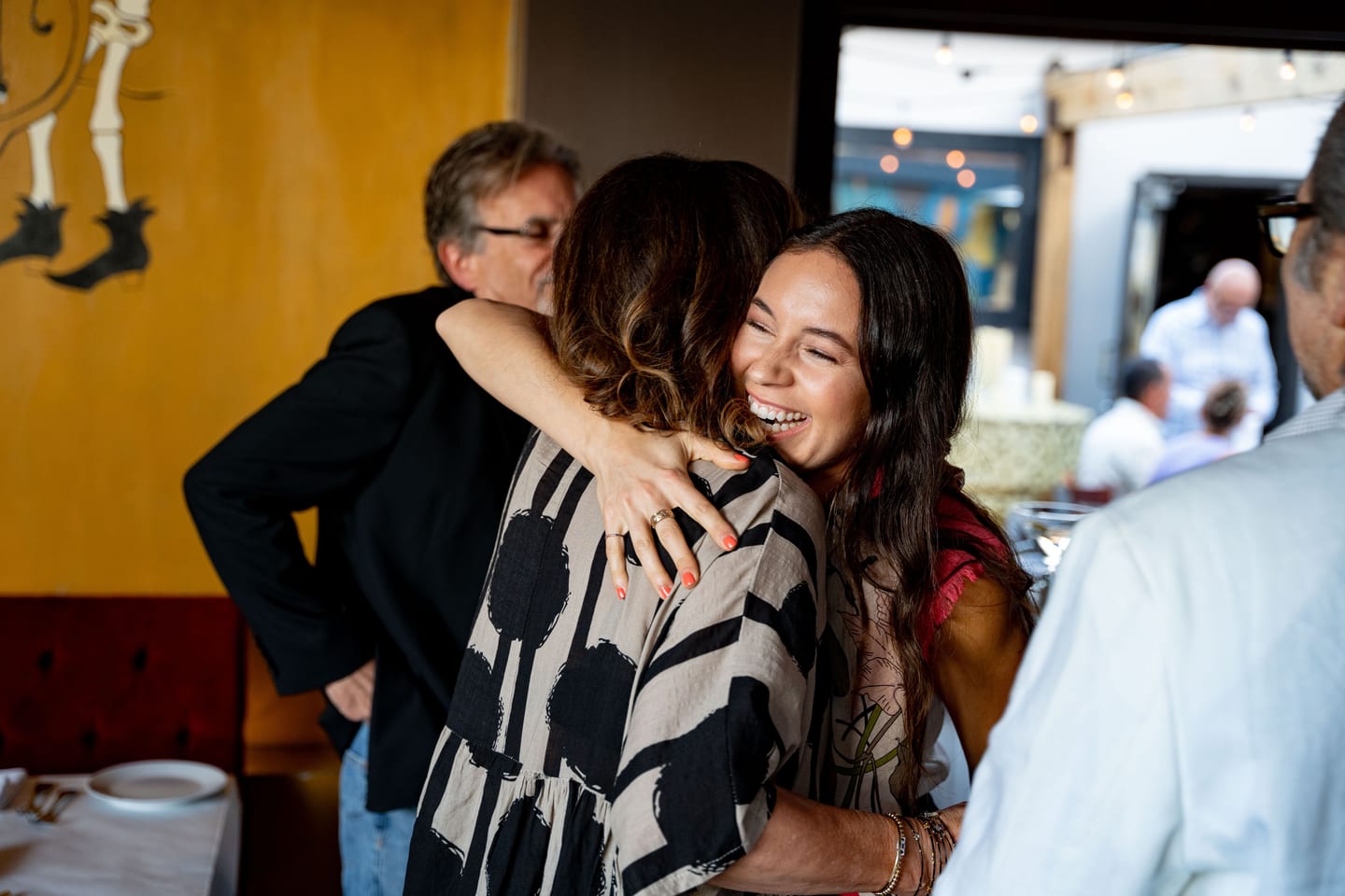 Host hugging a guest at a private birthday celebration