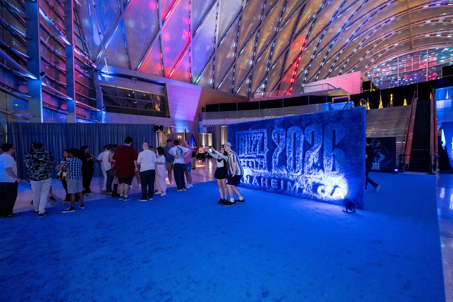 Guests on a blue carpet lining up to pose at the shag BlizzCon 2026 wall inside ARTIC