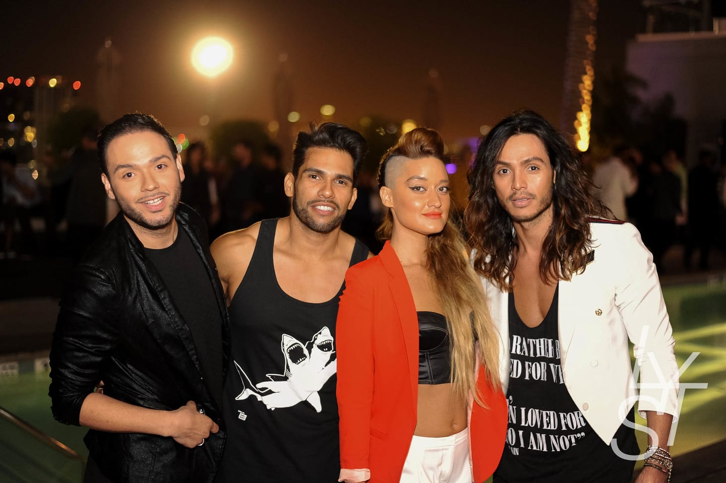 Group of four friends posing together at a nightlife event