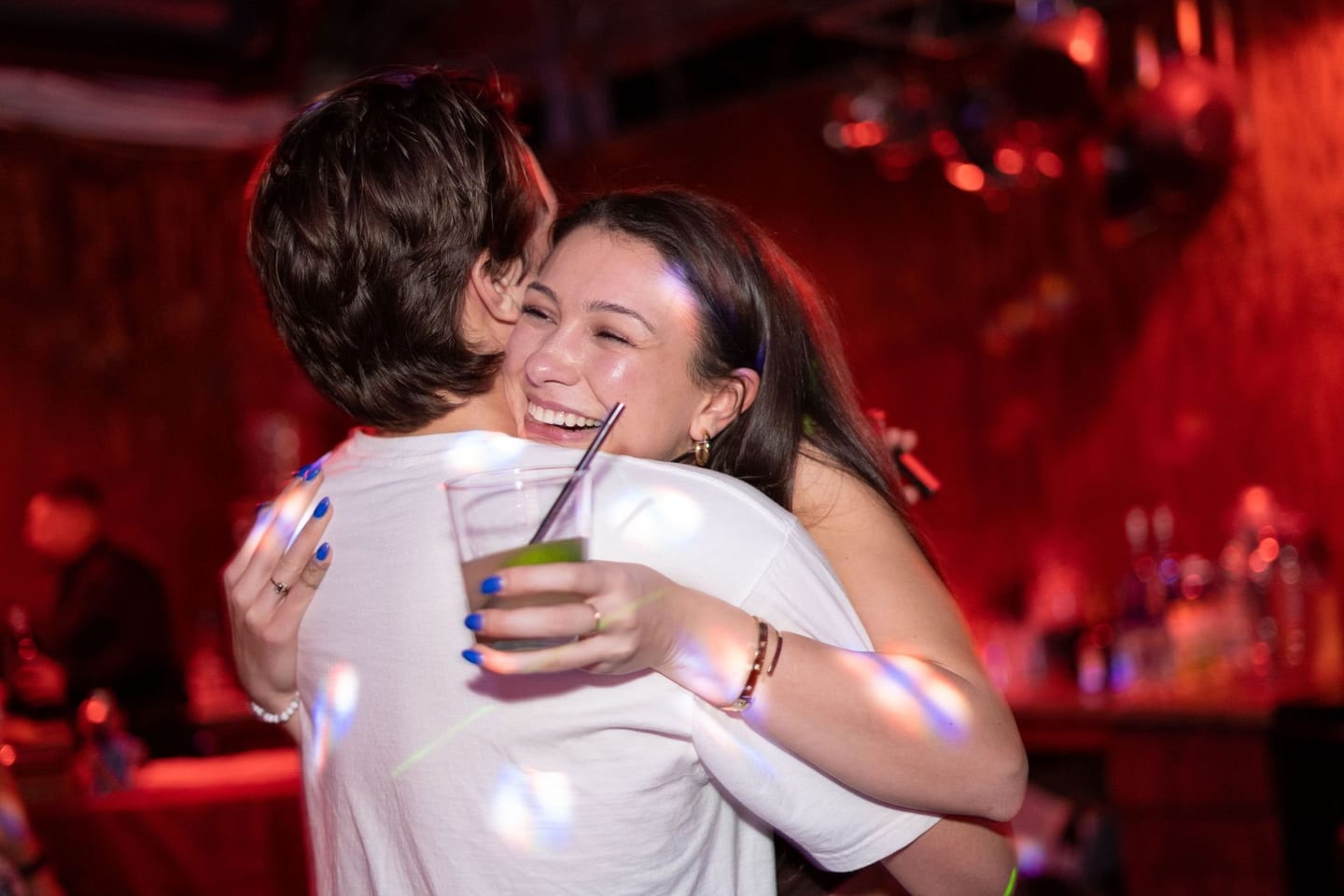 Two friends hugging on a dancefloor at a party