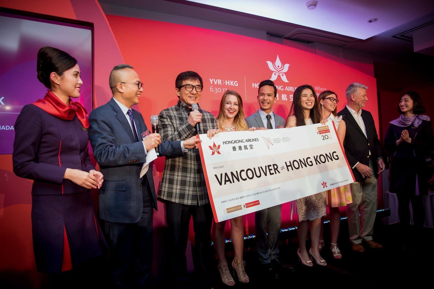 Jackie Chan presenting an oversized Hong Kong Airlines check on stage at a Los Angeles event