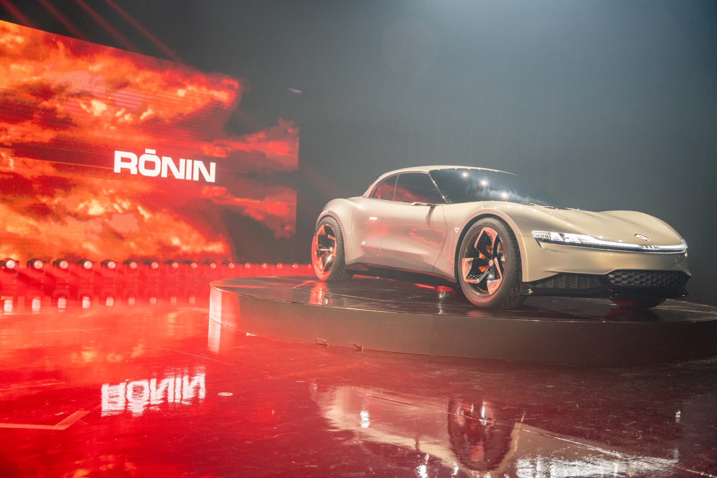 The Fisker Ronin grand tourer beside the red RONIN screen