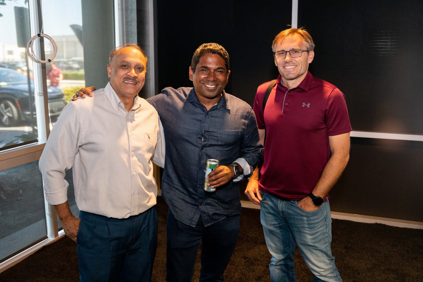 Three guests photographed together inside the venue