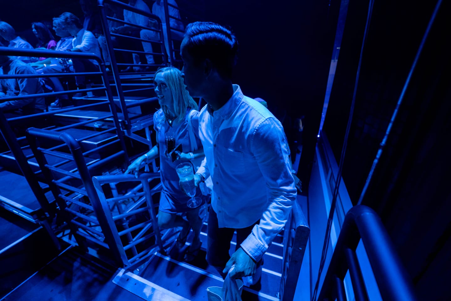 Guests on the grandstand stairs in deep blue light