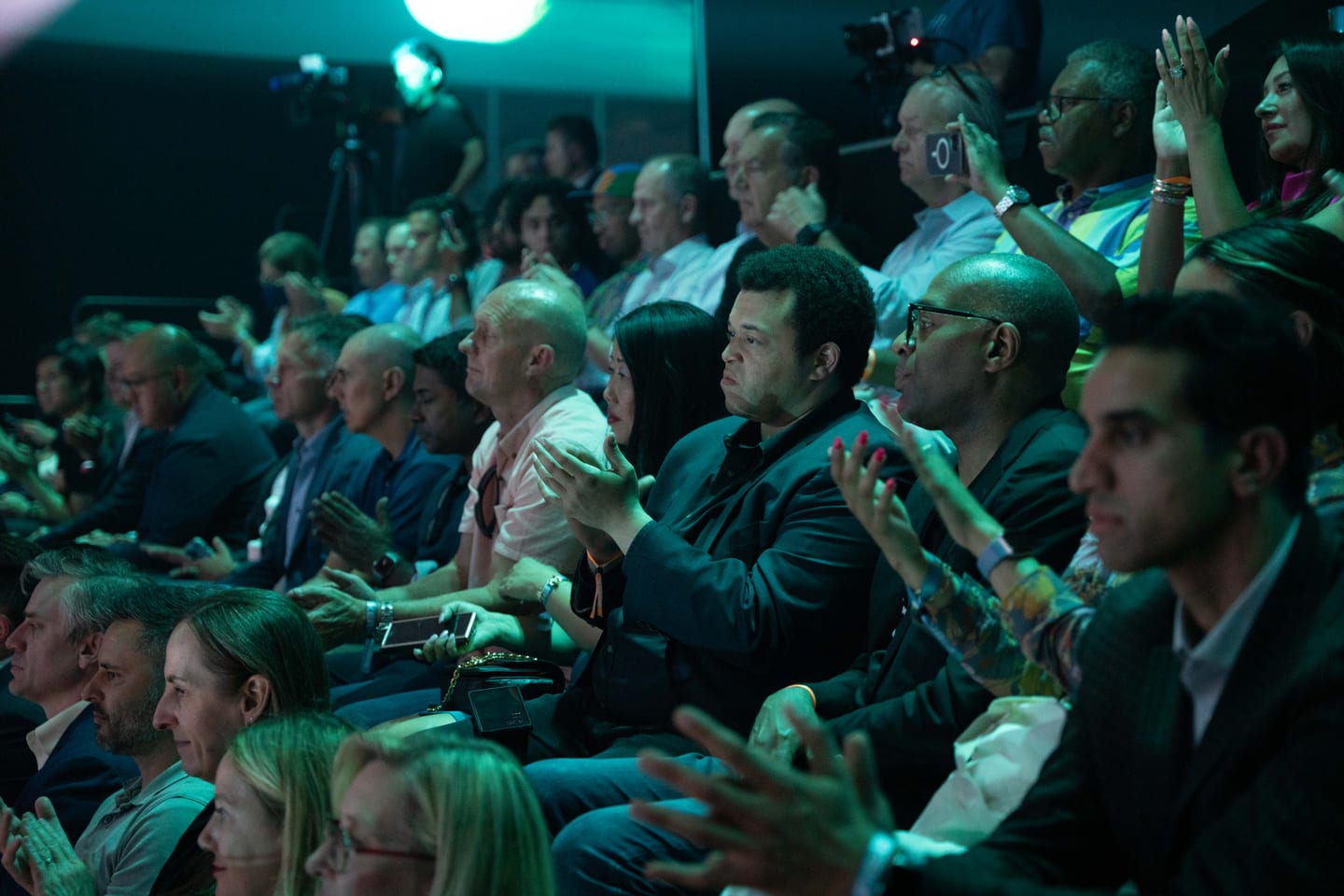The audience applauding in teal light