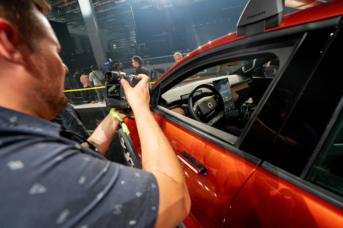 A videographer filming the cabin of the Fisker Alaska through its side window