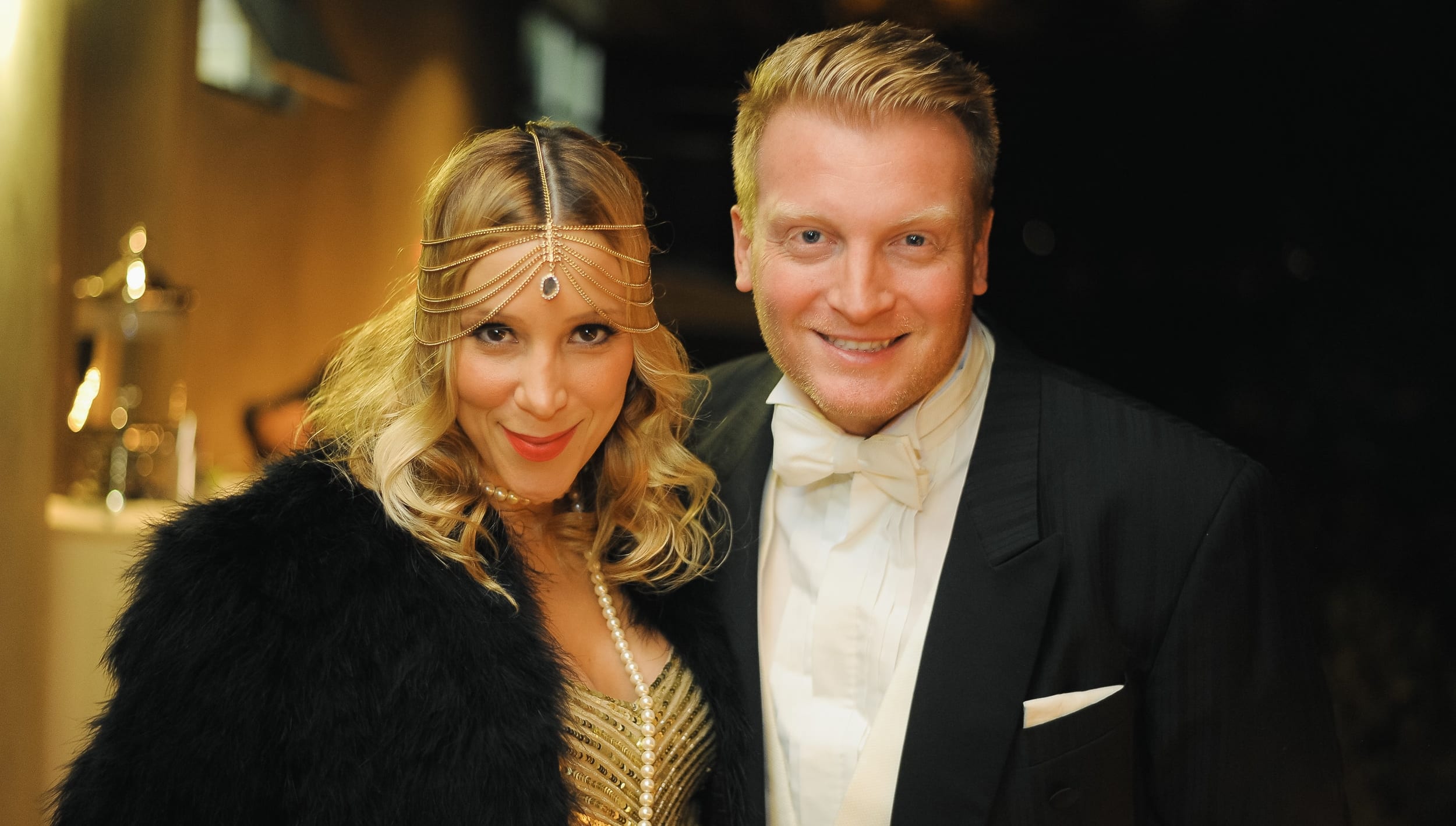 Couple in Gatsby-era formalwear at a themed private party