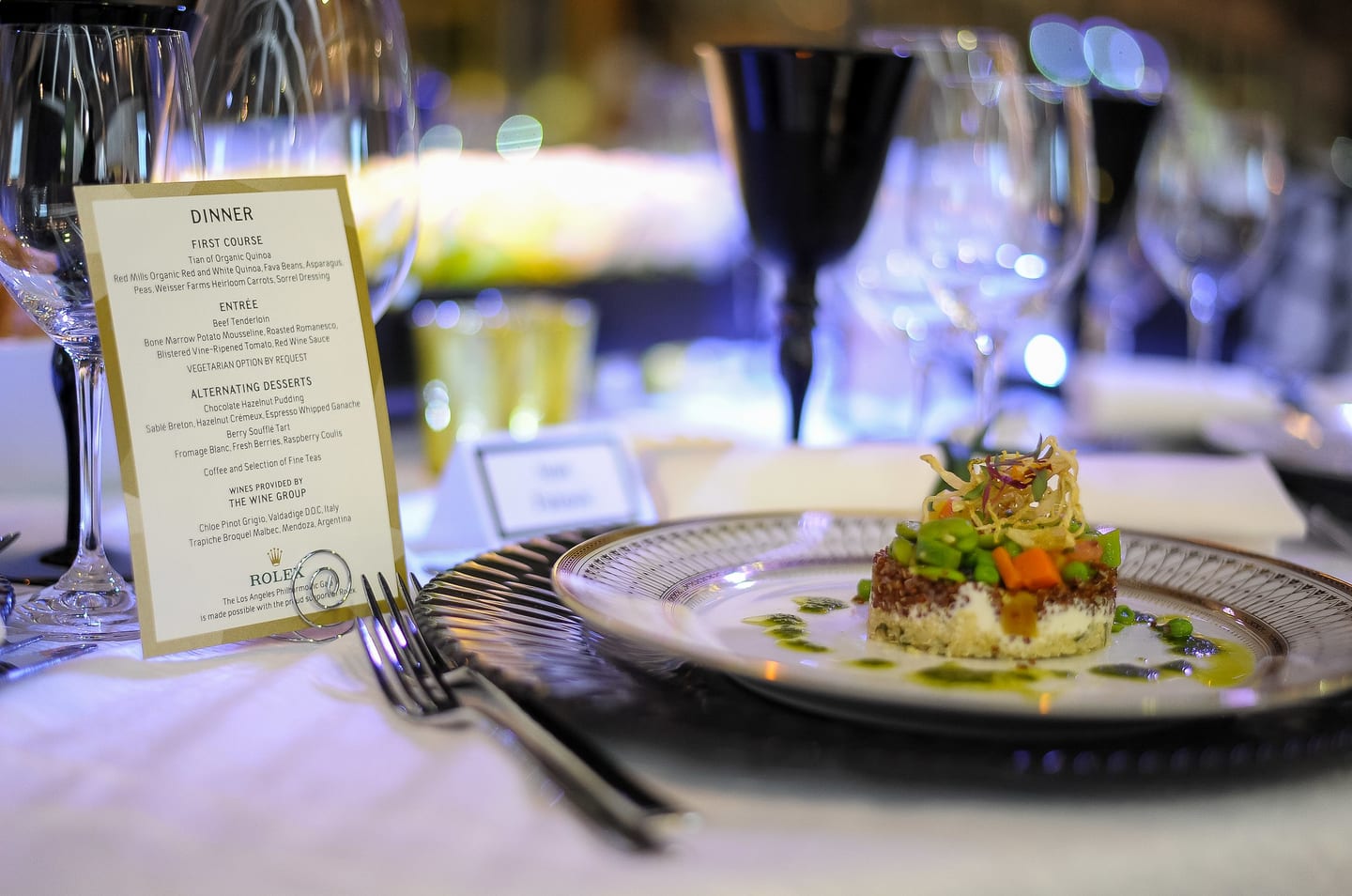 Dinner menu card and plated first course at a gala place setting