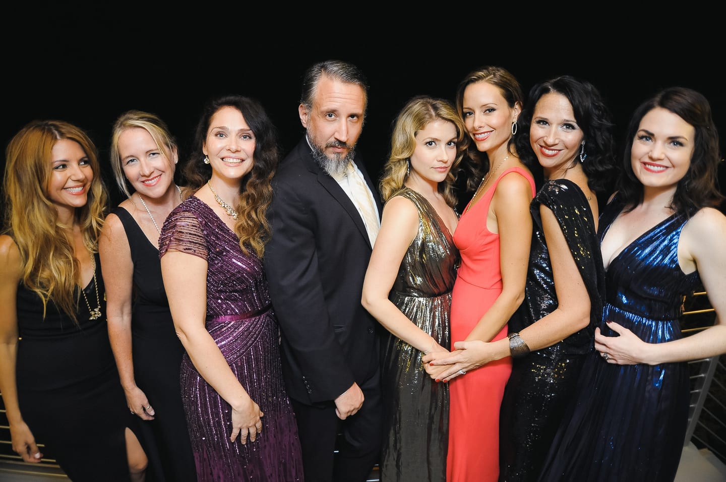Group in formal evening wear posing at an upscale private party