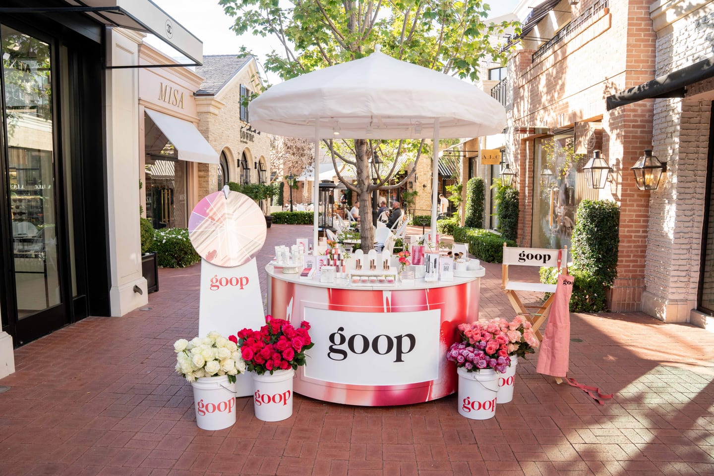The branded Goop pop-up kiosk with flowers and products at an outdoor mall in Pacific Palisades