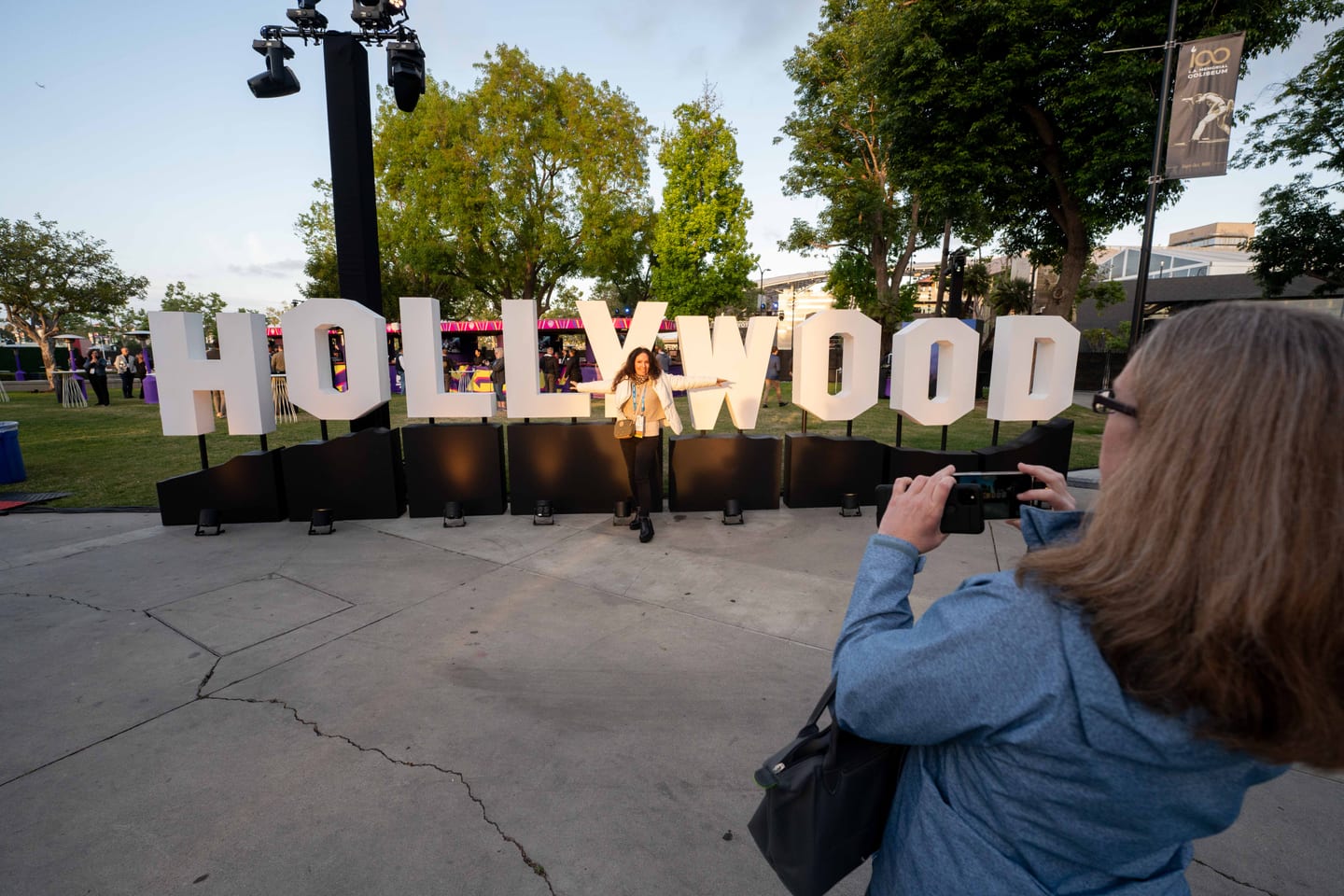 A delegate photographing a large HOLLYWOOD letter installation at an outdoor IPW activation