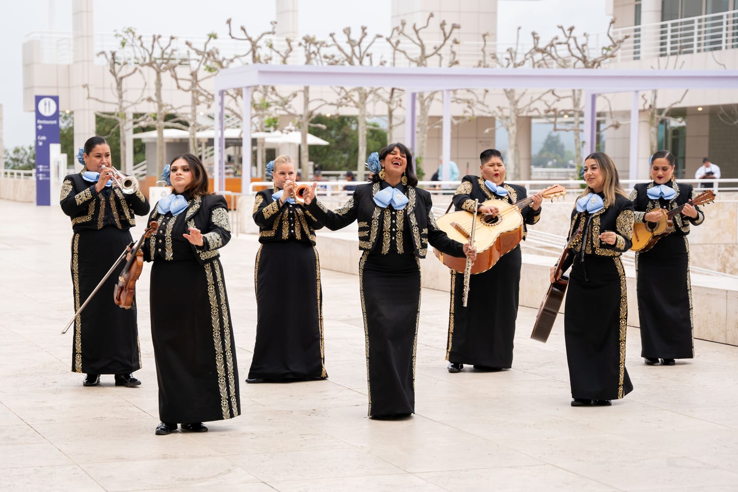 A group of women mariachi musicians performing in traditional charro suits for IPW delegates