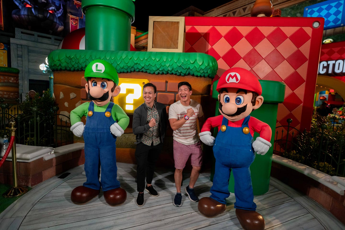 Costumed Mario and Luigi characters posing with IPW guests in Super Nintendo World at Universal Studios Hollywood