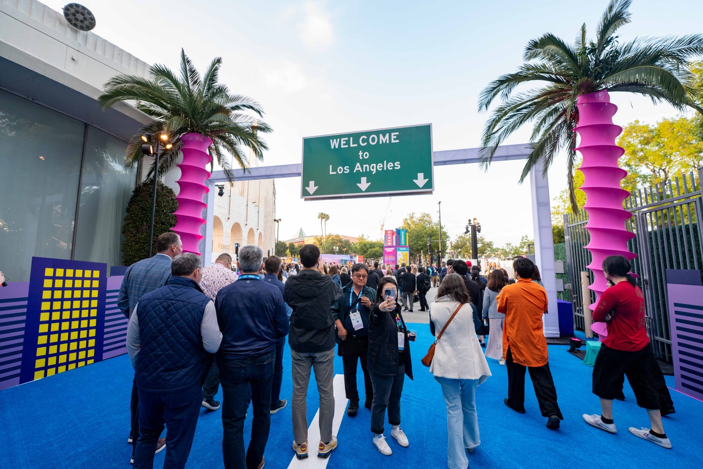 IPW delegates passing under a Welcome to Los Angeles gateway hung with papel picado banners at an outdoor reception