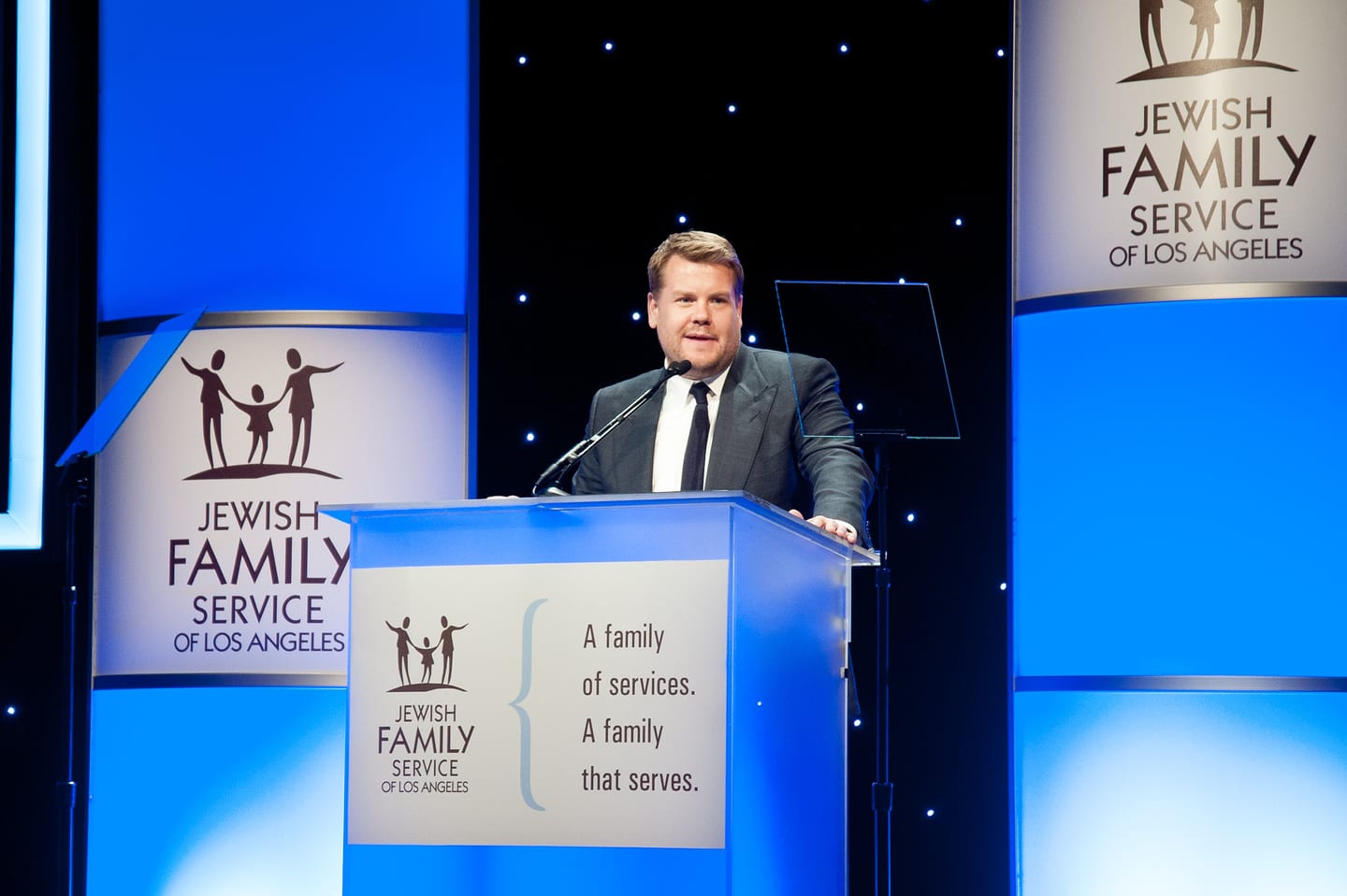 James Corden speaking at the podium at the Jewish Family Service of Los Angeles gala