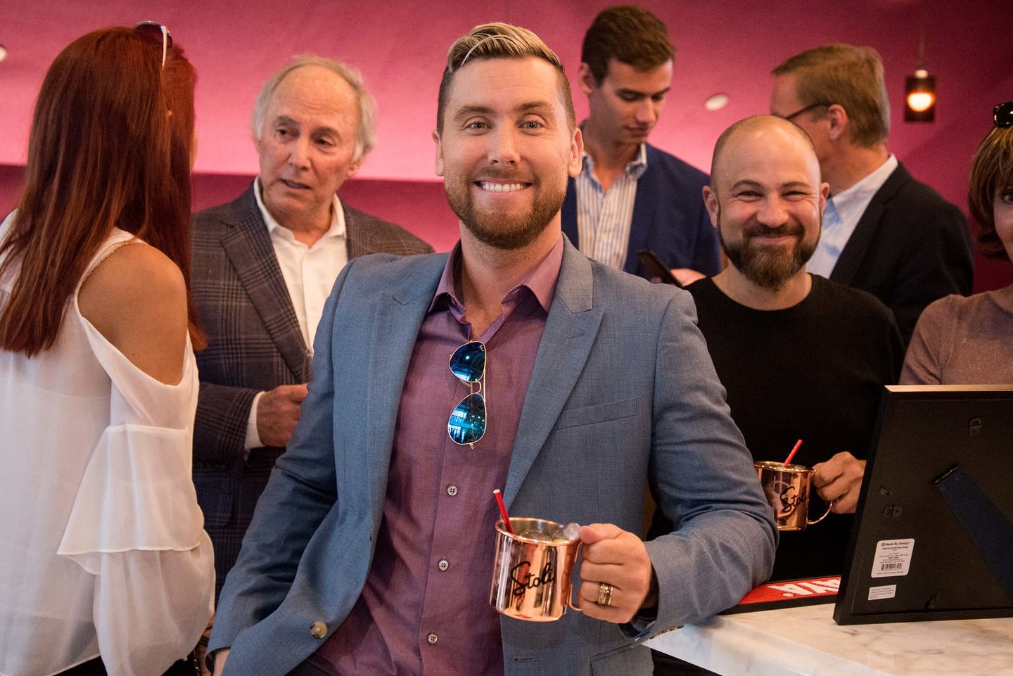 Lance Bass smiling and holding a copper Stoli mug during a Virgin and Stoli event in Los Angeles