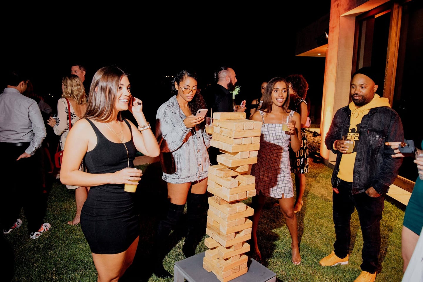 Guests playing giant Jenga on the lawn at a garden party
