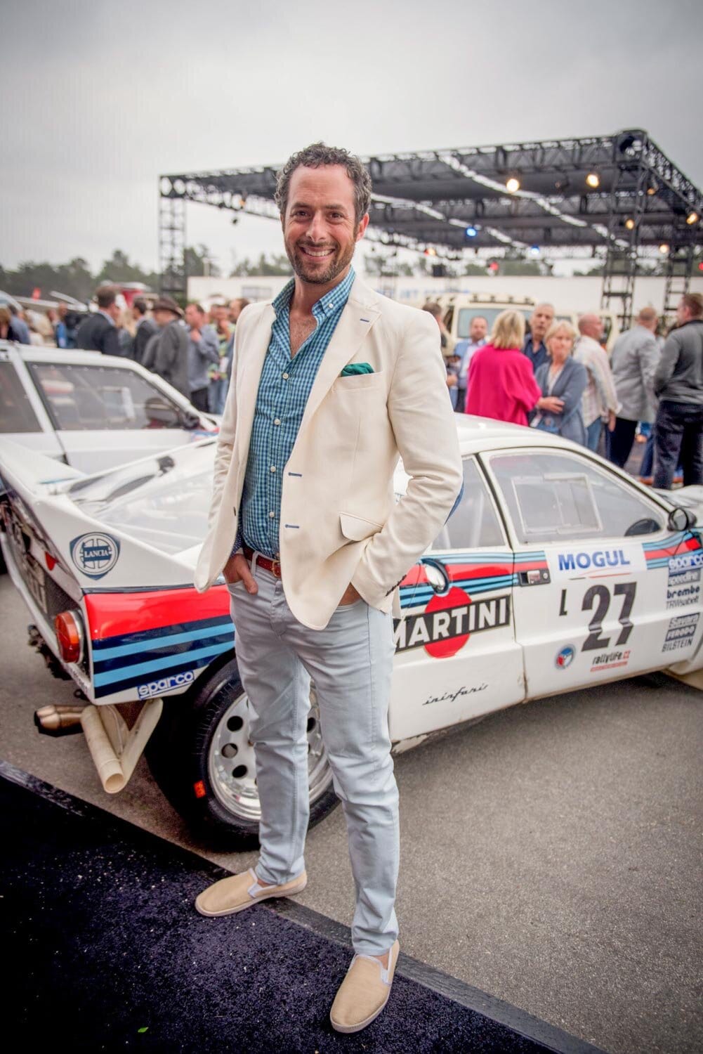 Guest beside a Martini racing car at an auto event