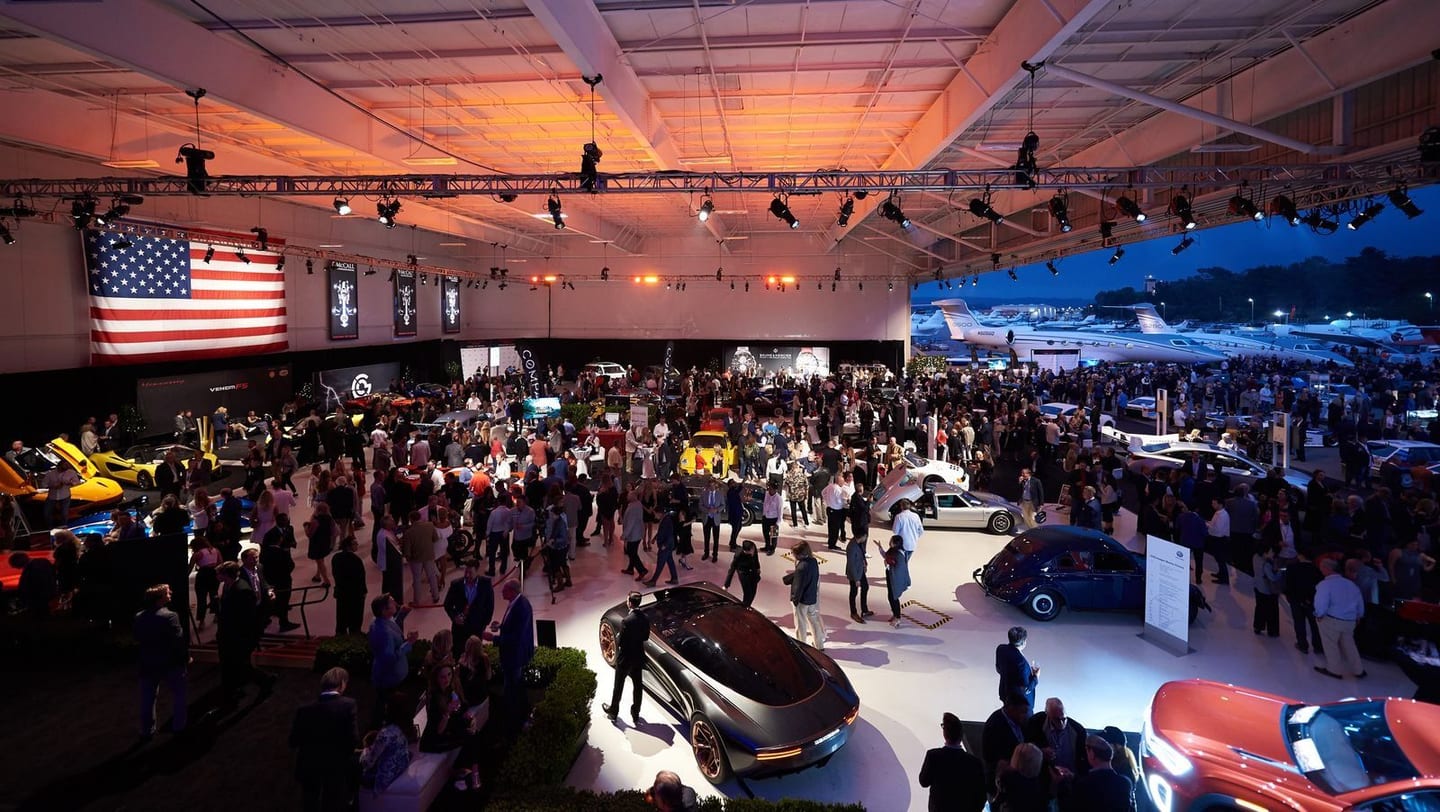 Crowd on the show floor at a Monterey Car Week automotive event