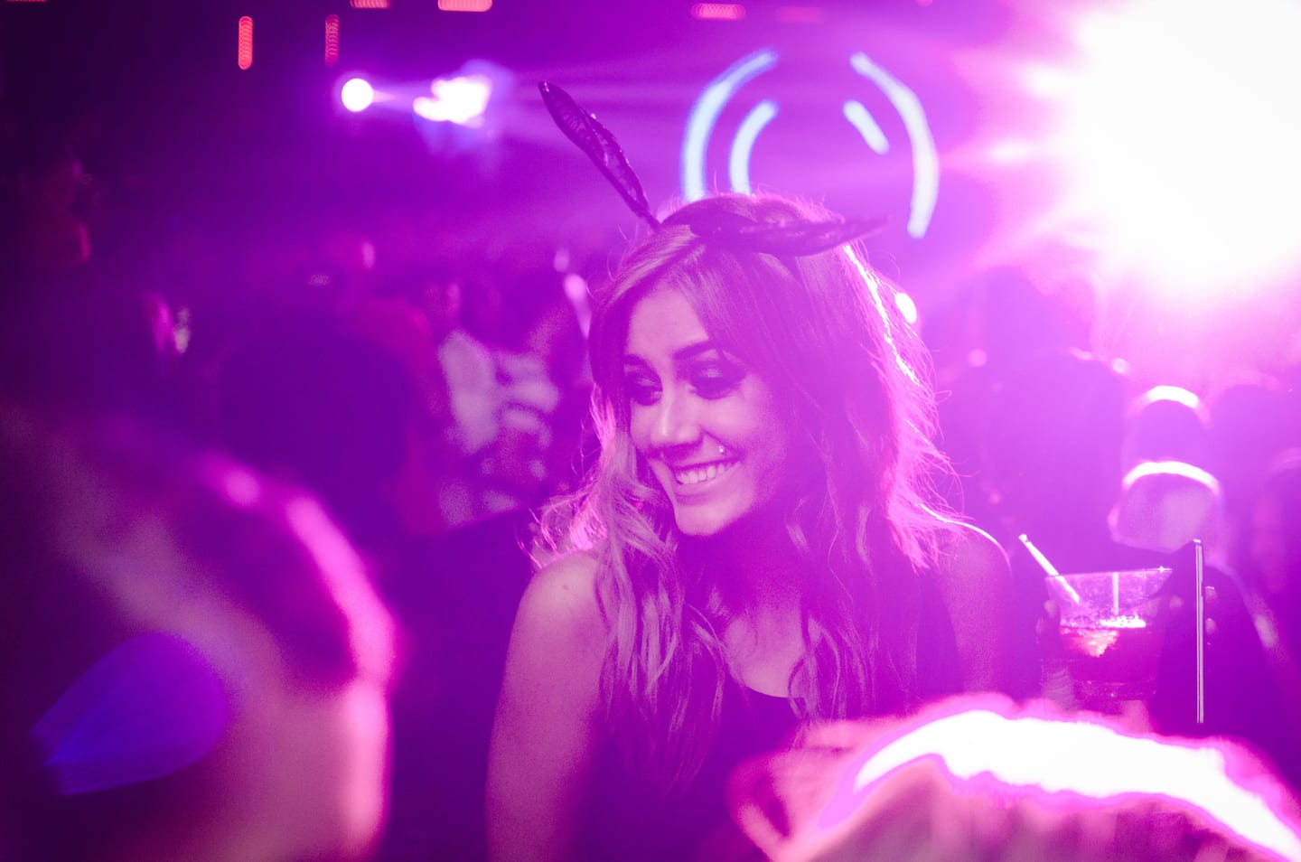 Guest smiling under purple neon lights at a club after-party