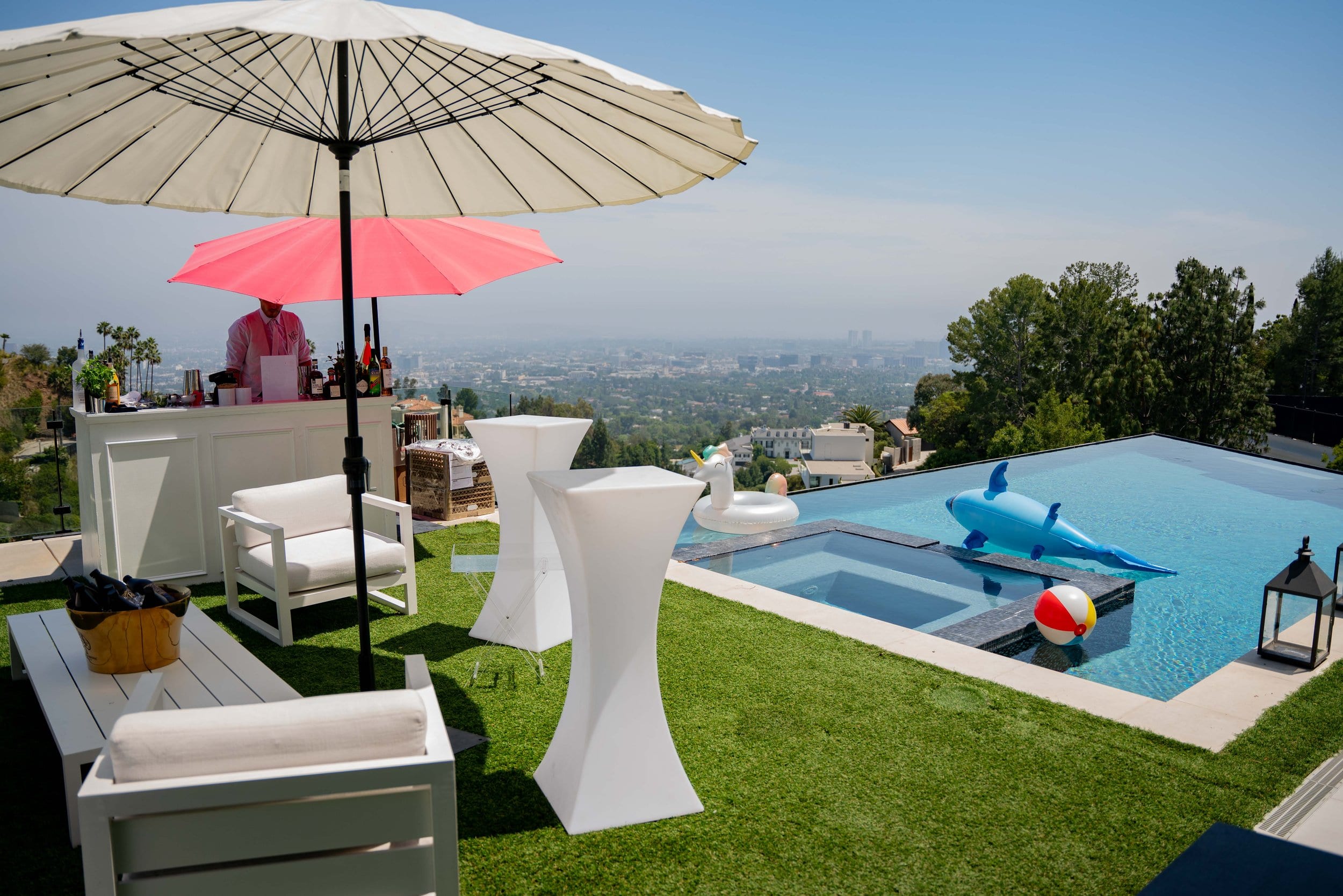 Poolside setup with cocktail tables and Los Angeles skyline views at a private NFL party in the Hollywood Hills