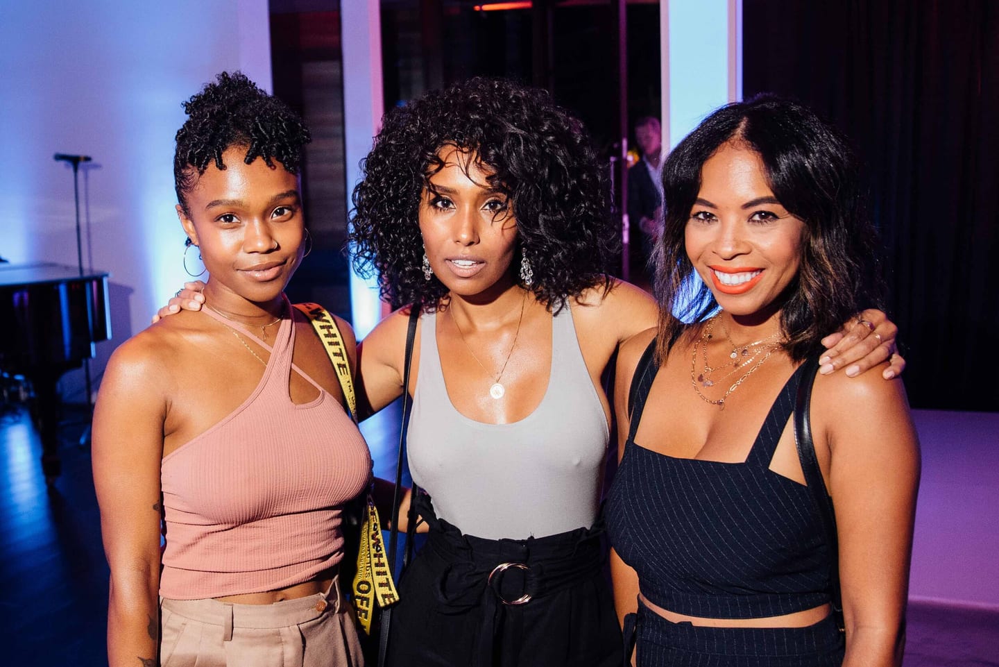 Three friends posing together at a nightclub party