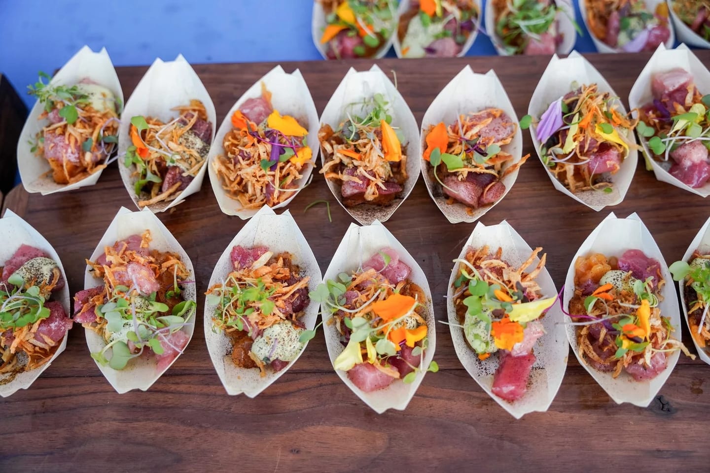 A wooden board of plated seafood tastings at the Off the Hook seafood festival on the Santa Monica Pier