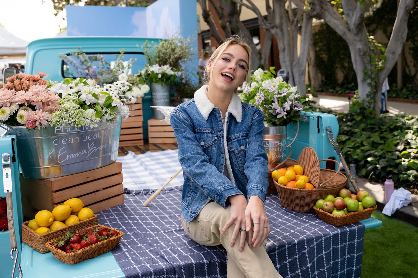Influencer Emma Brooks on a flower- and fruit-styled vintage truck at the Paul Mitchell Clean Beauty pop-up activation in Los Angeles
