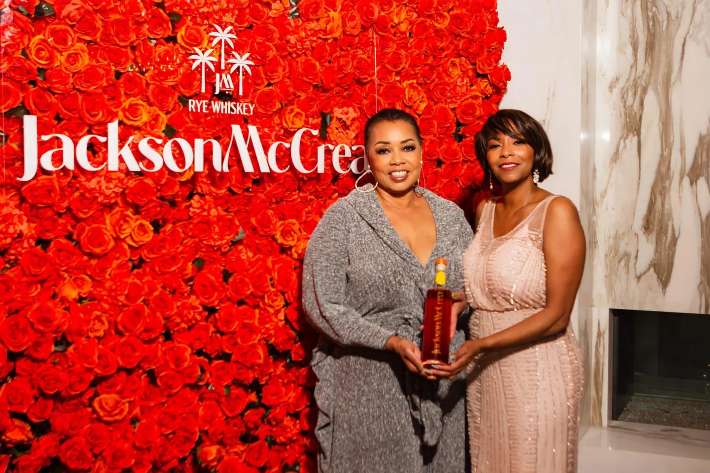 Two women founders holding a whiskey bottle at a launch event, photographed for Forbes
