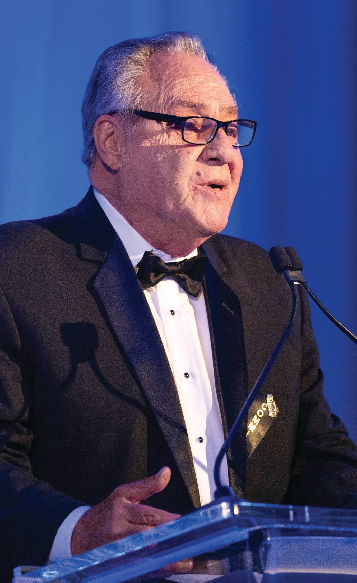 Honoree at a black-tie podium, photographed for Modern Luxury