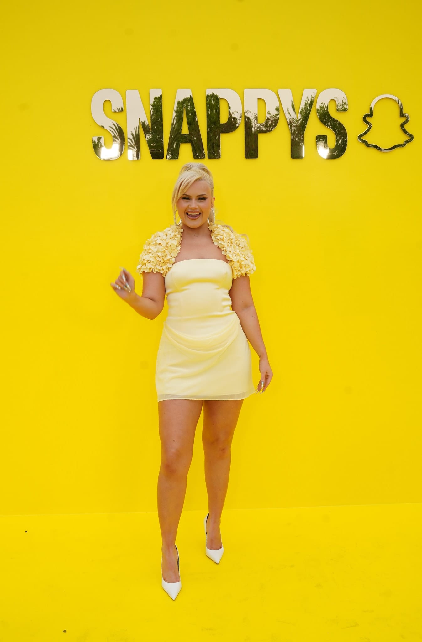 Influencer Ashlee Keating in a yellow dress on the yellow carpet against the SNAPPYS backdrop at Snapchat’s creator awards in Santa Monica